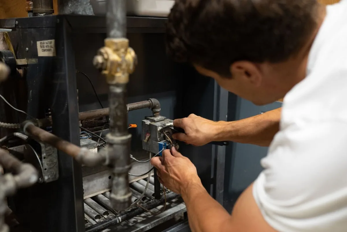 Reid Pro technician working on a furnace during a service call