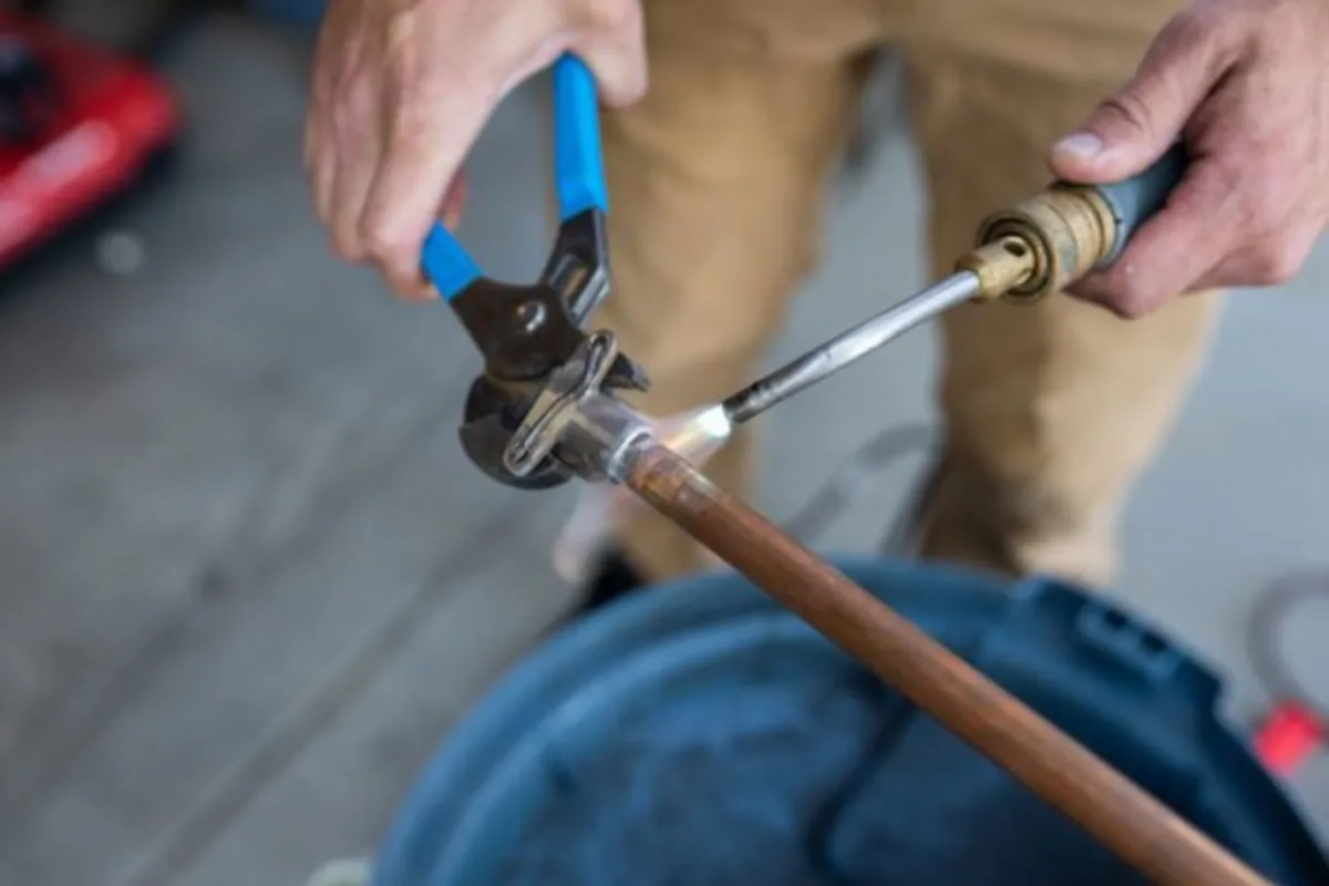 Reid Pro technician soldering copper pipe on a service call