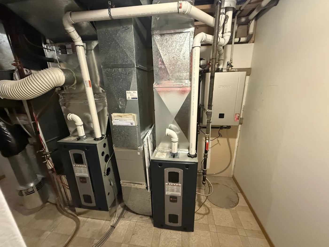 Wall-mounted tankless hot water system installed by Reid Pro