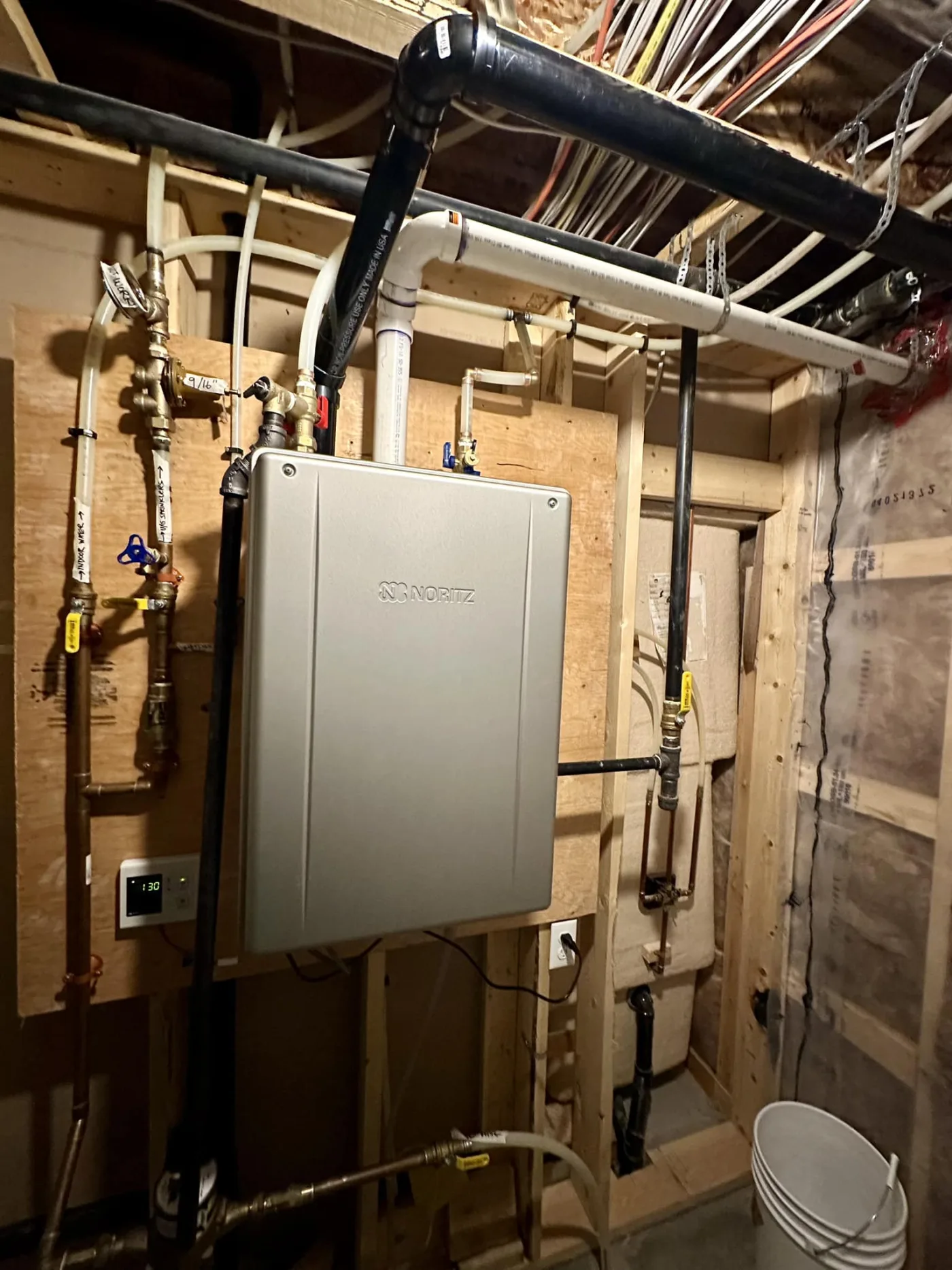 Wall-mounted on-demand hot water system installed by Reid Pro